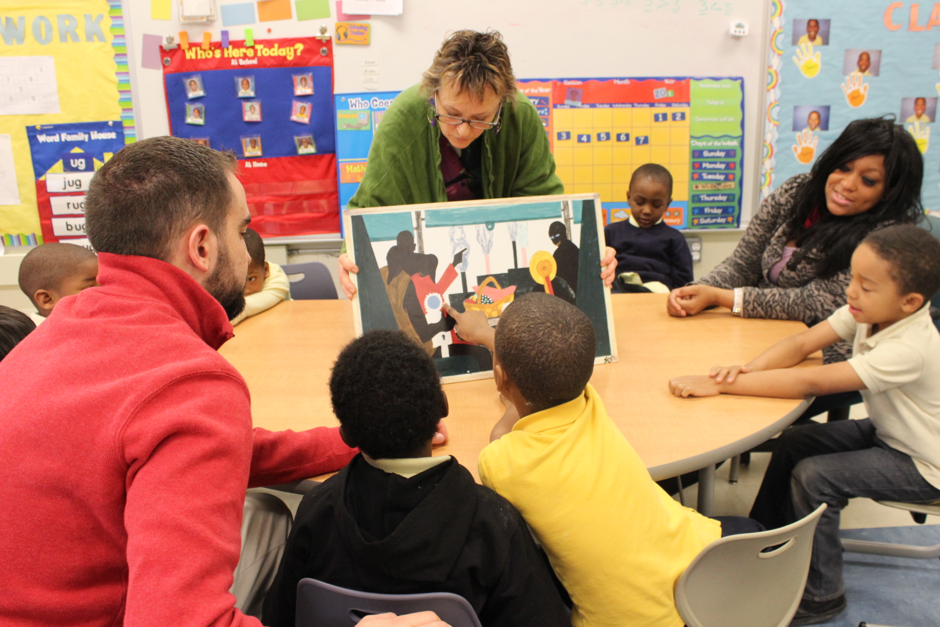 Donna showing an artwork to a group of students in a classroom